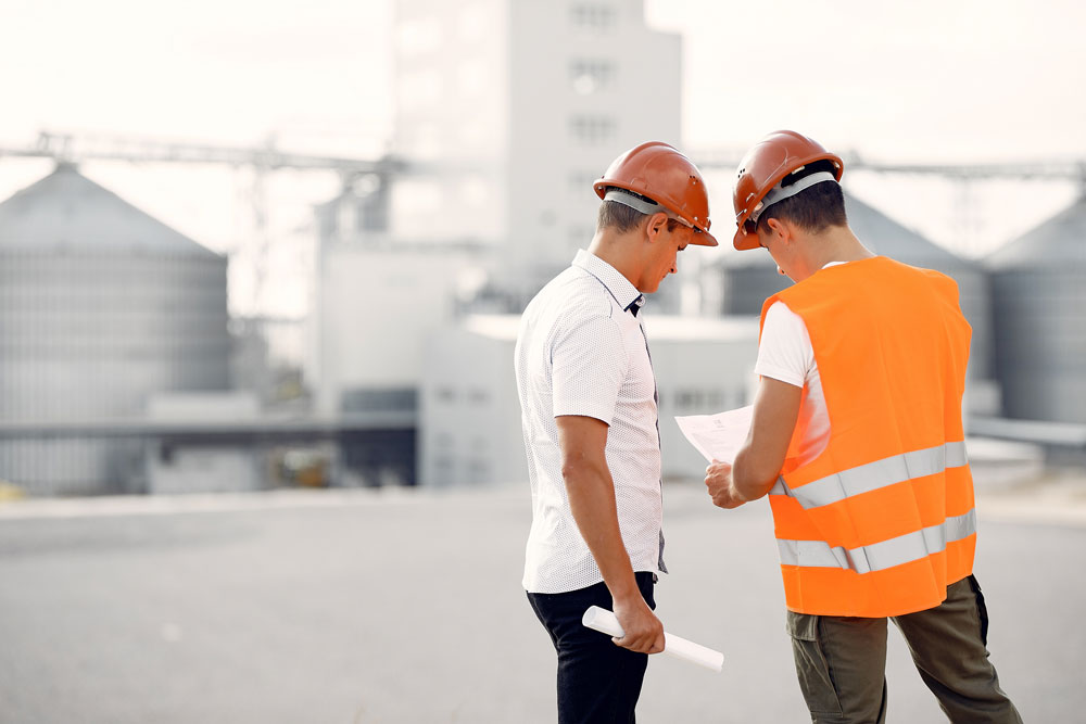 engineers-helmets-standing-by-factory